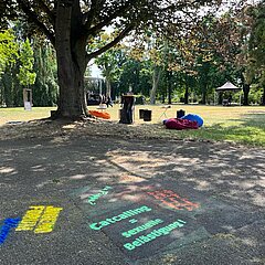 Boden-Graffitis gegen Catcalling auf Fußweg im Park