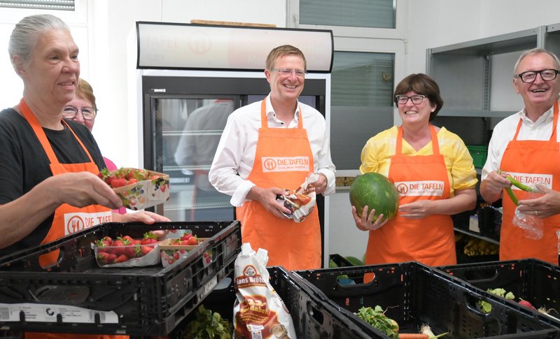 Ehrenamtliche mit Vorstandsvorsitzender der Diakonie Hessen Carsten Tag hinter Ausgabetresen