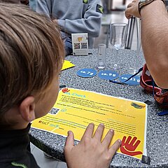 Schüler steht am Tisch und testet sein Wissen über Alkohol