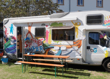 Bunt bemaltes Wohnmobil mit Biertischgarnitur