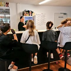 Jugendliche auf Barhockern vor einer Theke